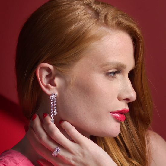 Woman with red hair wearing 14K white gold Cascade of Diamonds dangle earrings, showing beautiful movement and sparkle in a lifestyle setting