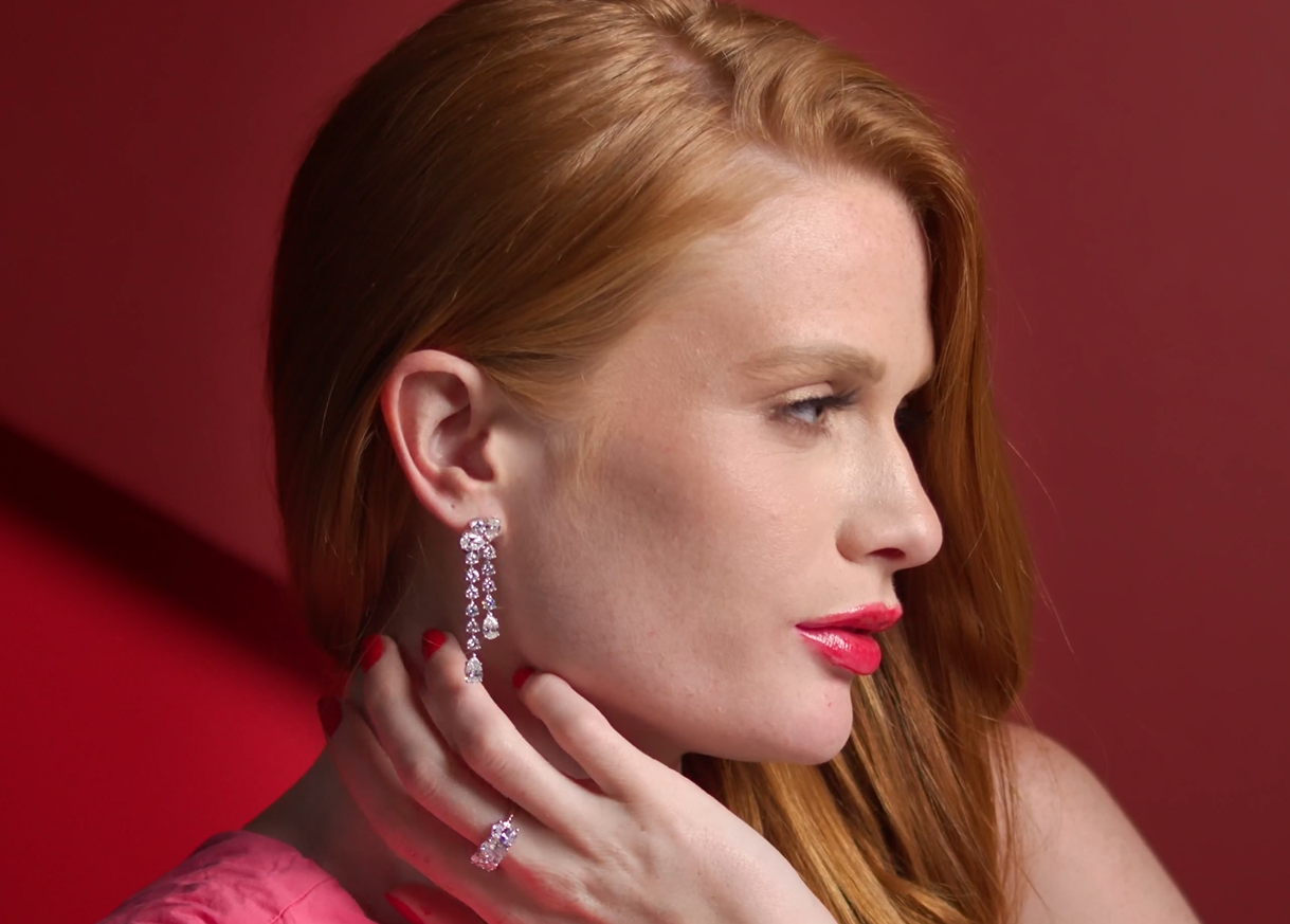 Woman with red hair wearing 14K white gold Cascade of Diamonds dangle earrings, showing beautiful movement and sparkle in a lifestyle setting